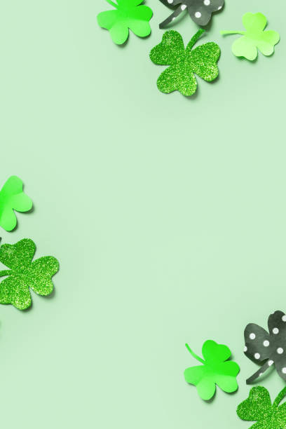 istock St. Patrick's Day balnk greeting card. Paper clover leaves on colored background with copy space 1465576450