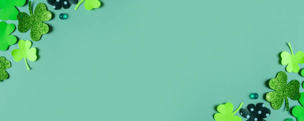 istock St. Patrick's Day banner. Paper clover leaves on colored background with copy space 1465576457