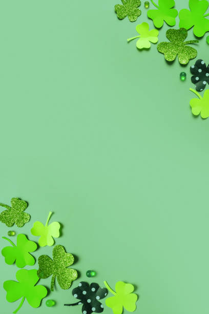istock Happy St. Patrick's Day greeting card mock up. Paper clover leaves on colored background 1465576464