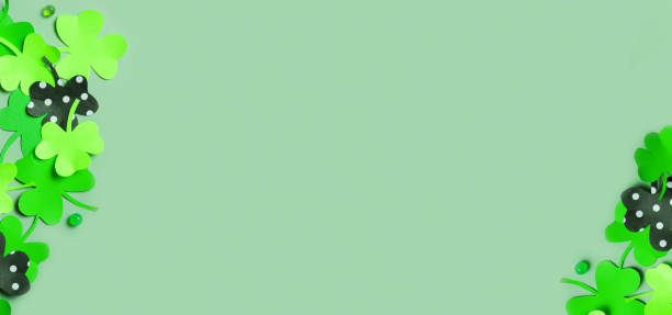istock St. Patrick's Day banner background. Paper clover leaves on colored background with copy space 1465576467