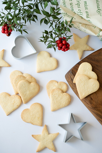 Homemade heart and star shaped cookies on white background with cochina flower