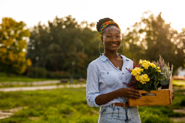 istock Florist holding a crate with potted flowers, smiling at camera 1465580660