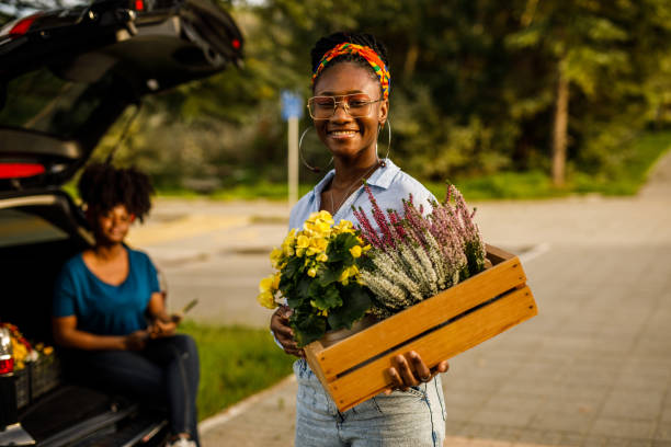 istock Florist holding a crate with potted flowers, smiling at camera 1465580663