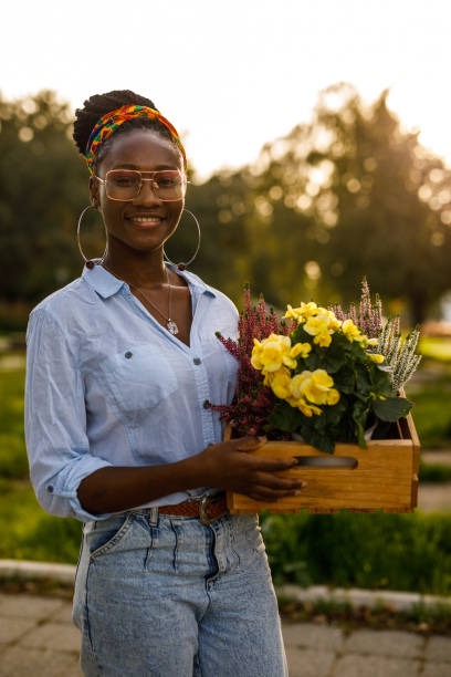 istock Florist holding a crate with potted flowers, smiling at camera 1465580664