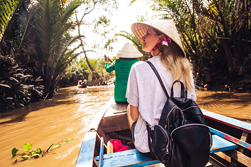 Female tourist on boat in Mekong River Delta, Vietnam