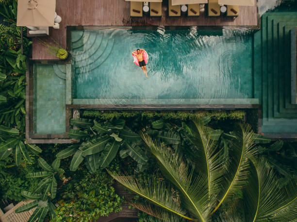istock Young man relaxing in resort swimming pool 1465582655