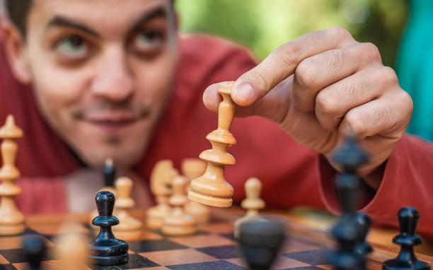 istock Man in chess game moves a piece, hand close up 1465582823