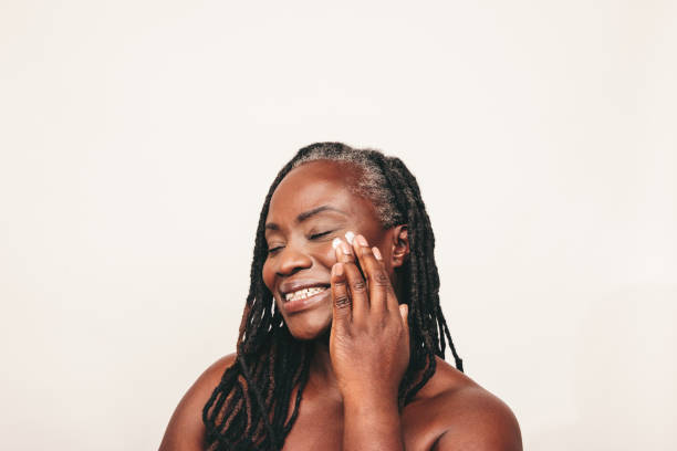 istock Happy mature woman applying moisturizing cream on her face 1465584277