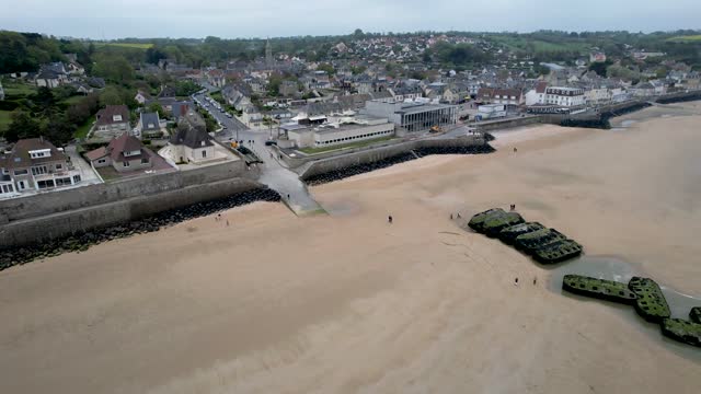 Aerial panning view of Arromanches les Bain, Normandy France with ww2 bunkers on beach