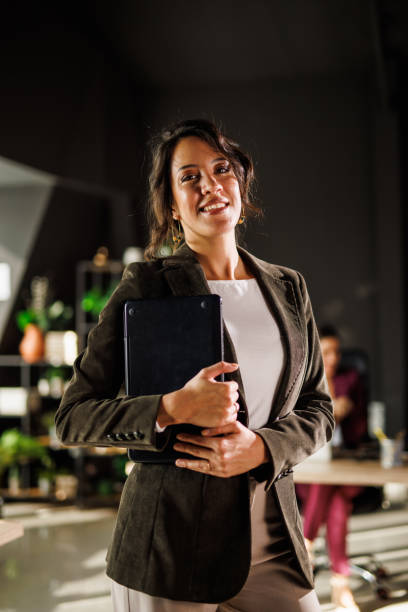 istock Charming brunette businesswoman standing in co-working office, smiling at camera 1465588355