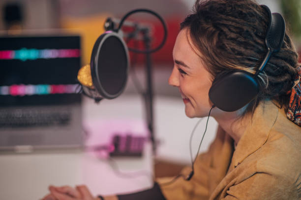 istock Woman in the podcast studio recording a show and talking 1465590144
