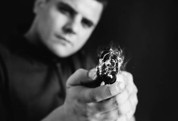 istock Man is holding gun in his hands. Isolated on black background. 1465590238