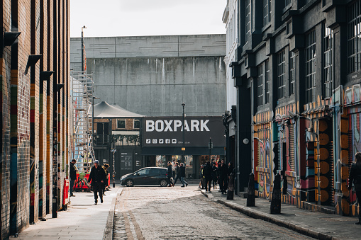 London, UK - February 09, 2023: View of Boxpark Shoreditch, a shipping container mall for independent fashion and lifestyle stores and cafes, from a nearby street, selective focus on the background.