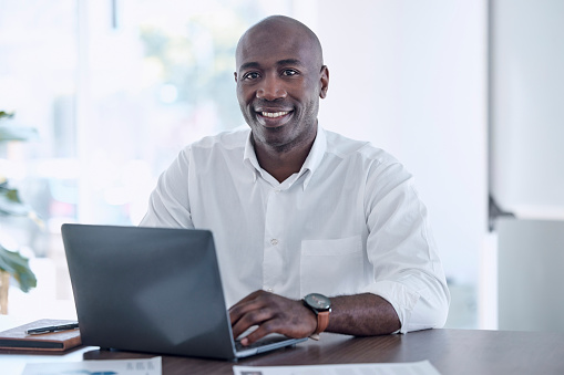 Ceo, black man and portrait at office laptop with smile working on report for marketing company. Professional corporate worker at workplace desk with document for project development.