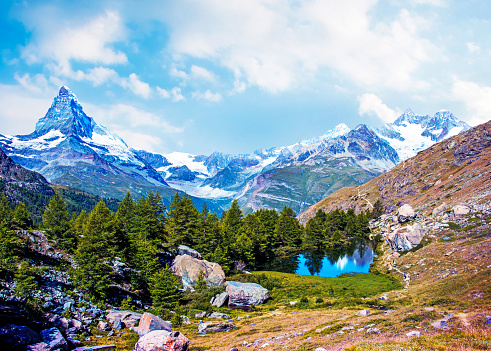 Mountains and clouds in the valley. Natural landscape high in the mountains. Mountain range through the clouds. Landscape in the summertime. Large resolution photo for design.