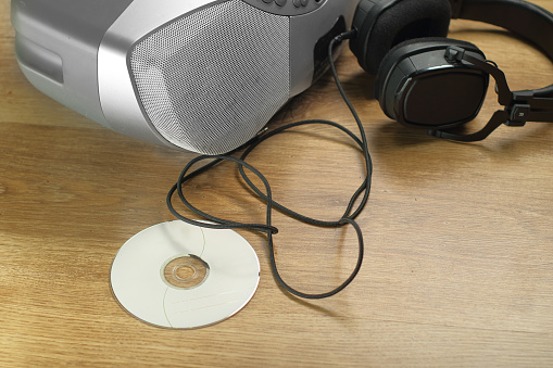 compact disc with cd player and headphones in the background