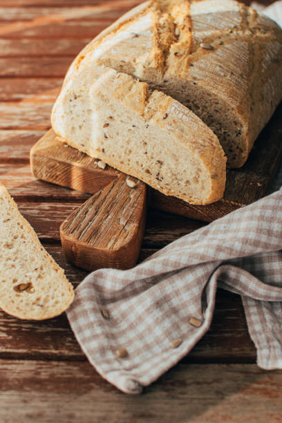 istock Bread loaf on rustic wooden cutting board and napkin 1465601462