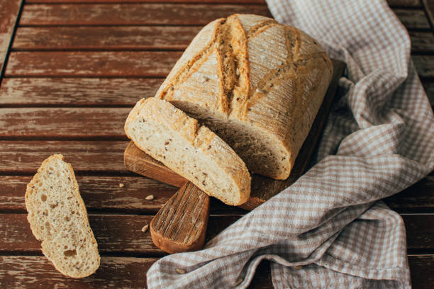istock Bread loaf on rustic wooden cutting board and napkin 1465601466