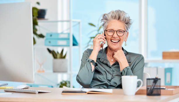 istock Ceo, business and woman on call with joy about successful startup company plan while feeling cheerful. Laughing, funny and comic communication on a phone call with a mature female executive 1465604095
