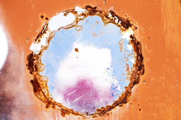 Orande fiery red rusty abstract painted metal plate texture and background with blue hole for your yext. texture of grunge old plate with stained cracked paint and brown rust. Copy space