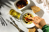 Woman dipping olive oil