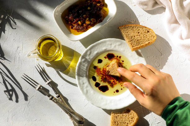 Woman dipping olive oil stock photo