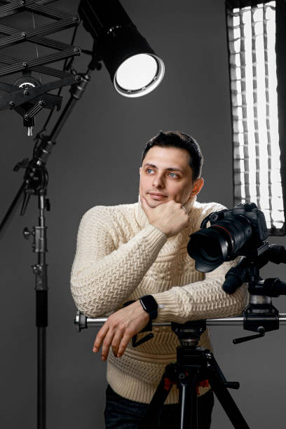 istock Professional handsome photographer with digital camera on tripod 1465606761