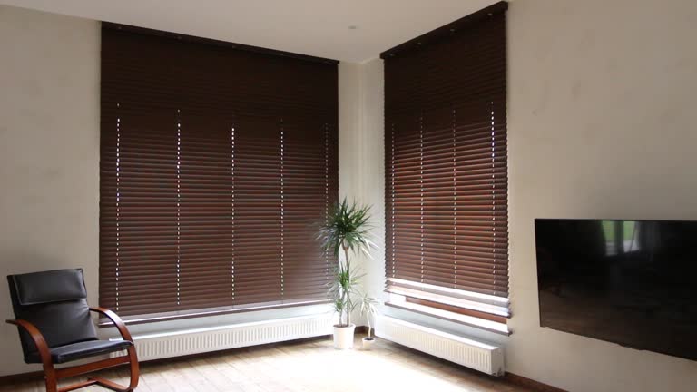 Wooden blinds closing down on large windows in the interior.