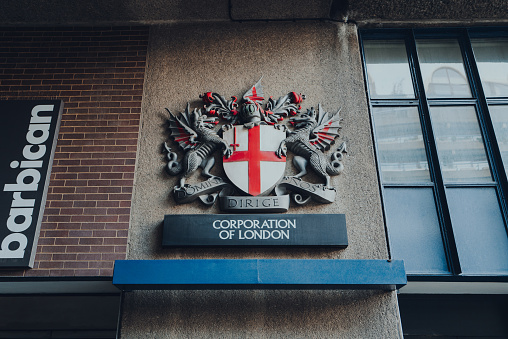 London, UK - February 02, 2023: Sign for The City of London Corporation, the municipal governing body of the City of London, on a wall of a building in Barbican.