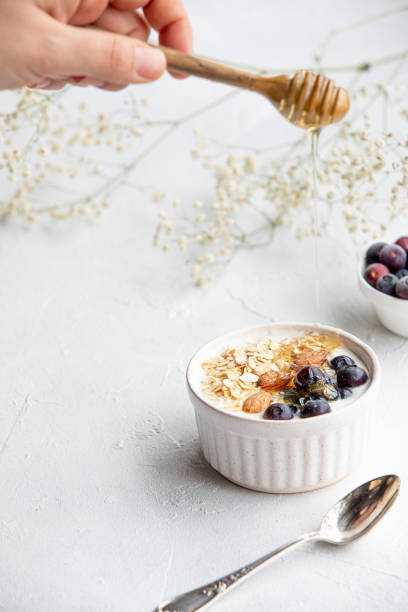 Yogurt bowl with oatmeal, almonds, blueberries and honey. stock photo