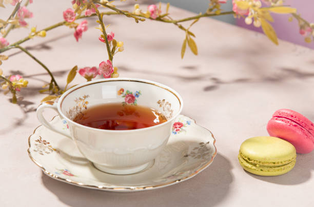 Tea in an antique teacup on the side macarons. stock photo