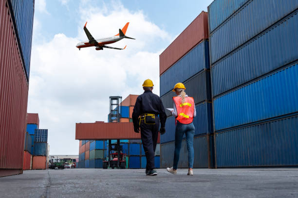 istock Industrial worker works with co-worker at overseas shipping container port . Logistics supply chain management and international goods export concept . 1465612328