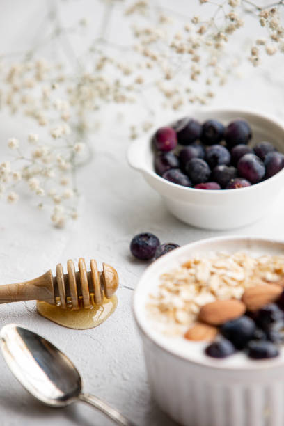 Yogurt bowl with oatmeal, almonds, blueberries and honey. stock photo