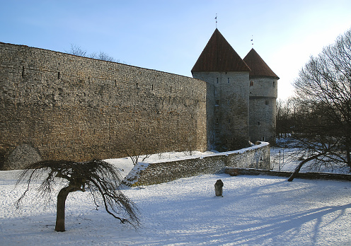 Two defensive towers in the city wall of Tallinn, Estonia. Winter scene with the low sun casting long shadows.