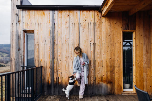 istock A Happy Beautiful Blonde Woman Covered With A Blanket Using Her Mobile Phone While Relaxing Outdoors With Her Playful Dog 1465621386