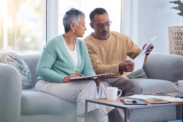 finance, documents and senior couple on sofa with bills, paperwork and insurance checklist in home, life or asset management, elderly black people on couch with financial, retirement or mortgage debt - hayat sigortası stok fotoğraflar ve resimler