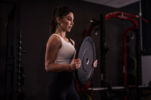 Young serious athletic woman exercising at the gym