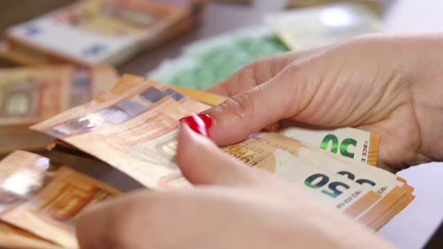 Counting Euro cash money in female hands on the table
