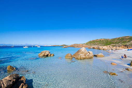 People enjoying a beautiful October day by the Bassa Trinità Beach, one of the naturalistic treasures of La Maddalena Island