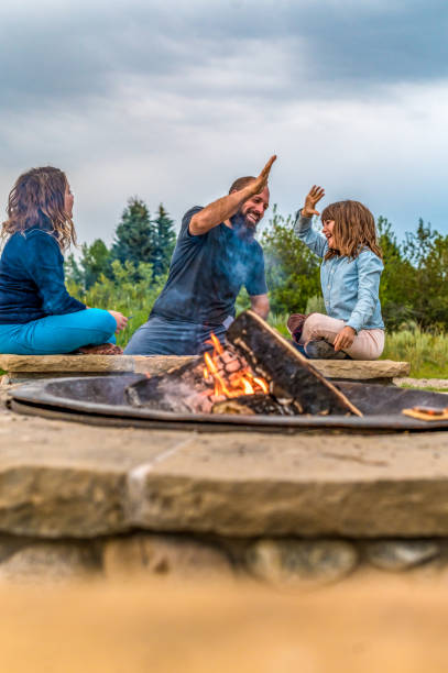 istock Father on a camping trip with his daughters playing cards around a campfire 1465625706