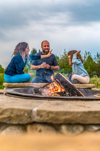 istock Father on a camping trip with his daughters playing cards around a campfire 1465625802