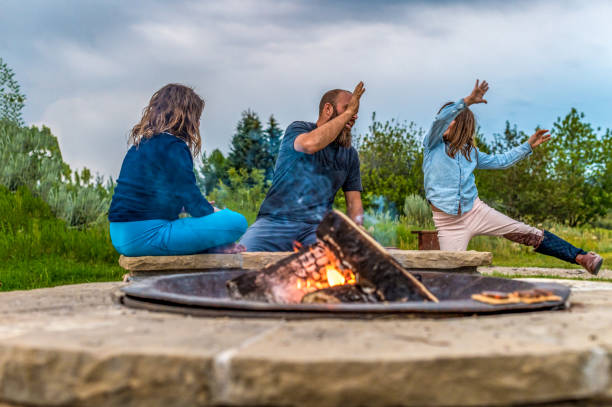 istock Father on a camping trip with his daughters playing cards around a campfire 1465625895