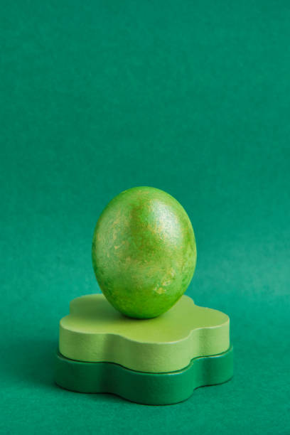 istock Painted green egg on wooden round podium. Monochrome. 1465627176
