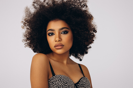 Beauty portrait of woman with afro posing in studio.