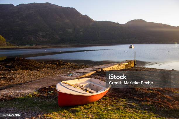 Small Red Rowboat On The Shores Of Loch Duich In The Golden Light Of Late Afternoon Stock Photo - Download Image Now