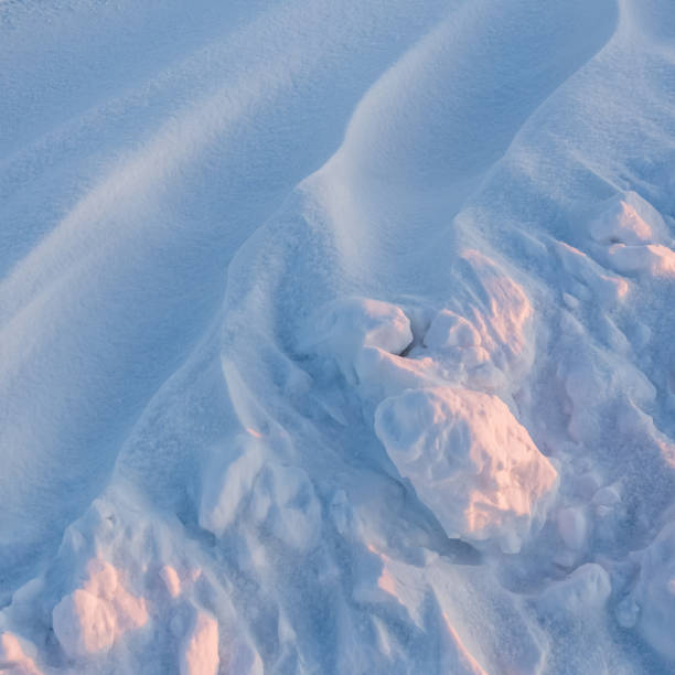 istock Snowdrift waves in sunset light, winter background of snow waves 1465629224
