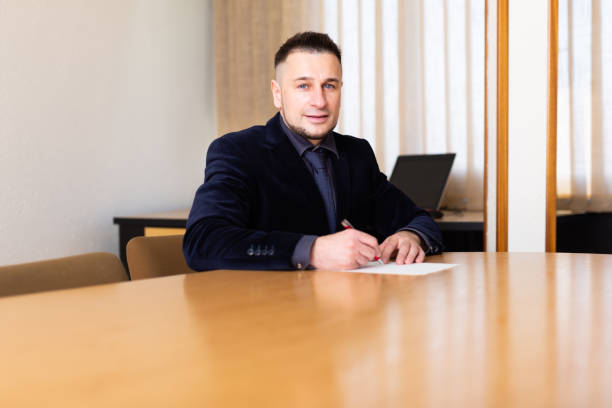 istock Businessman signs documents while sitting at the negotiation table in office 1465631175