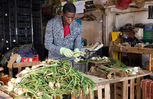Kigali, Rwanda - March, 2013: A woman in selling fresh vegetables in the market.