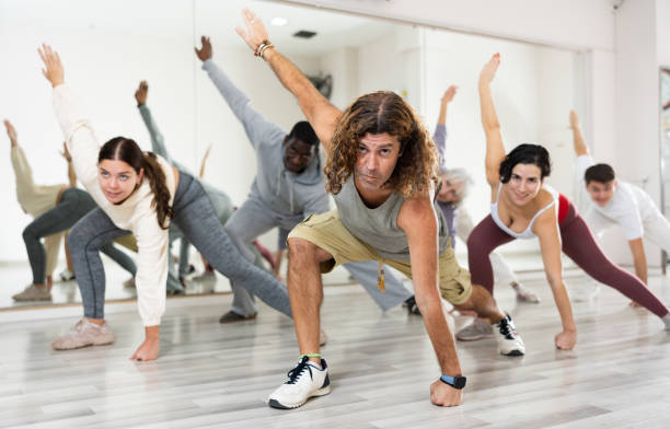 Happy caucasian man learning new modern dance in group dance lesson