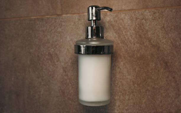 istock liquid soap isolated on bathroom wall. push-button liquid soap. close up of a silver push button 1465631791